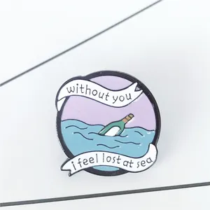 Macro detail of enamel drift bottle brooch with text without you I feel lost at sea