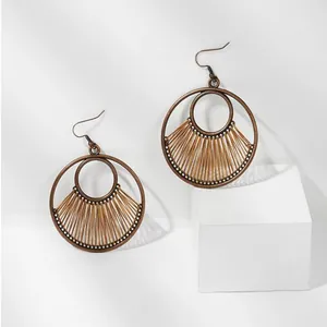 Detail of vintage geometric round earrings featuring fan-shaped woven brown wire patterns