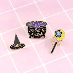 Detail of Sweet Witch enamel pins set with glitter magic hat, cauldron and moon wand