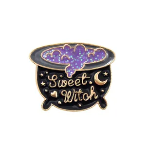 Detail of black Sweet Witch cauldron enamel pin with purple glitter and golden accents