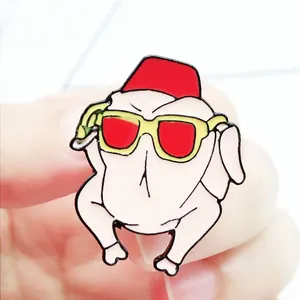 Close-up of a funny turkey enamel pin with red sunglasses and a red fez on a lapel