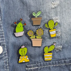 Set of 6 colorful enamel plant pins featuring cacti and sunflowers on denim fabric