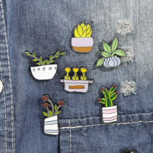 Set of 5 colorful enamel cactus and succulent pins styled on blue denim fabric