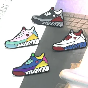 Detail von vier bunten Sneaker-Emaille-Pins mit Herzmustern auf einer Zeitschrift