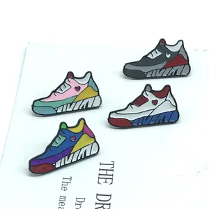 Details von vier bunten Sneaker-Emaille-Pins mit Herz-Akzenten auf weißem Hintergrund