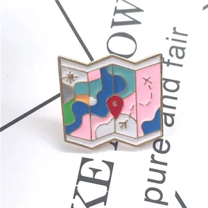 Detailed close-up of a colorful enamel travel map brooch with gold plating and red pin
