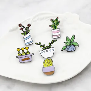 Detail of 6 cartoon enamel pins featuring green potted cacti and plants on a white tray