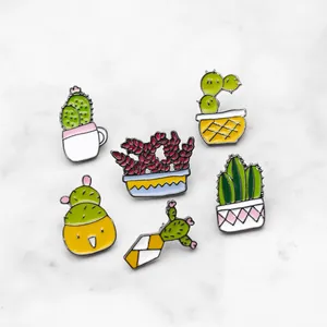 Ensemble de cinq broches émaillées cactus succulentes colorées sur fond de marbre