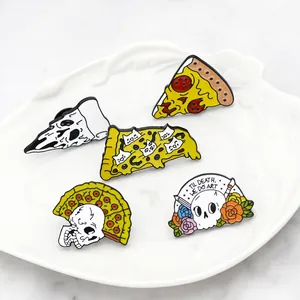 Détail de pins en émail colorés punk squelette et pizza sur plateau en céramique