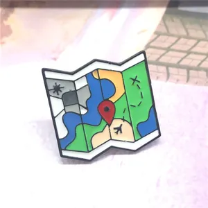 Macro shot of colorful enamel map brooch featuring landmarks and red location icons