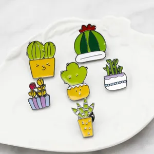 Vue à plat de six broches colorées en émail sur un plat blanc en céramique sur marbre