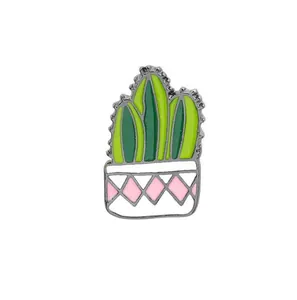 Détail de la broche cactus en émail vert avec motif losange rose sur pot de fleurs