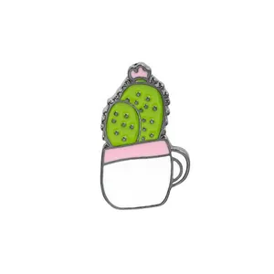 Détail d'un pin's en émail cactus vert dans un pot blanc avec une fleur rose