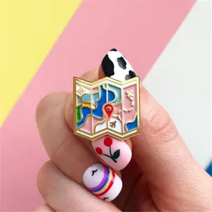 Detailed close-up of a colorful enamel map brooch with an airplane and location pins