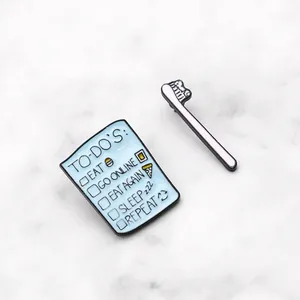 Creative enamel pins set featuring a mini to-do list notepad and a pink toothbrush design