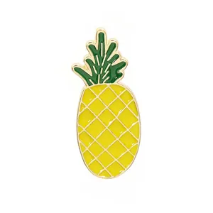 Detail of yellow enamel pineapple brooch pin with golden metal grid and green leaves
