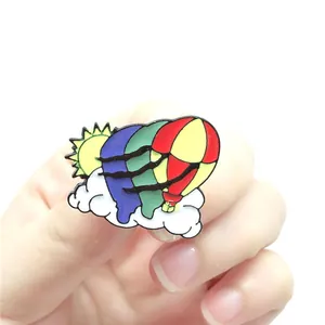 Detailed view of colorful enamel hot air balloon brooch with sun and clouds design