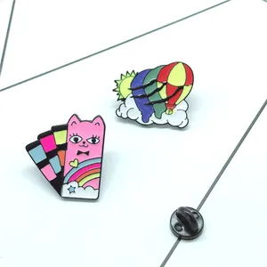 Detailed view of colorful cartoon cat and hot air balloon enamel pins with butterfly clutch