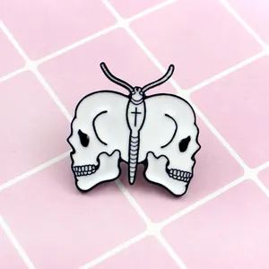 Macro detail of gothic enamel butterfly brooch featuring white skulls and cross