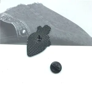 Reverse side of MAGIC enamel pin with textured metal backing and black rubber clutch