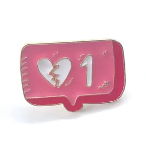 Macro detail of enamel pin featuring pink notification bubble and broken heart design