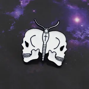 Detail of white skull butterfly enamel pin with black cross on a galaxy background