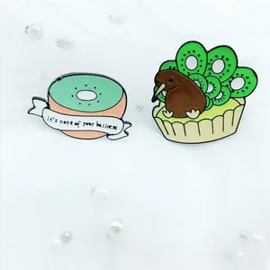 Macro detail van kiwi en vogel emaille pins op decoratieve witte parel mesh stoffen