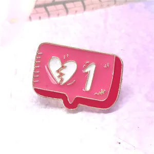 Macro shot of pink enamel notification bubble brooch with a cracked heart symbol