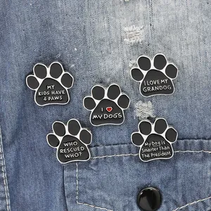 Five-piece set of paw print enamel pins featuring pet slogans on blue denim fabric