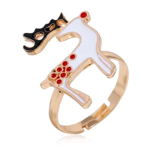 Detail van kerstring met rendier van wit email en rode stippen op een gouden band
