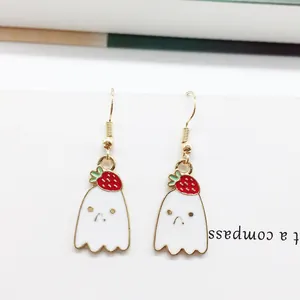 Close-up of cute ghost earrings with strawberry motif and golden metal hooks