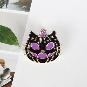 Halloween enamel pin with black cat and purple pumpkin design featuring gold star details