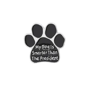 Macro shot of black enamel dog paw pin badge with My Dog is Smarter Than The President text