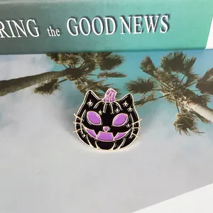 Macro shot of Halloween purple devil pumpkin cat brooch with golden edge and enamel details