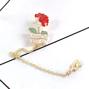 Red and white rose enamel brooch with Painting the Roses Red banner and chain