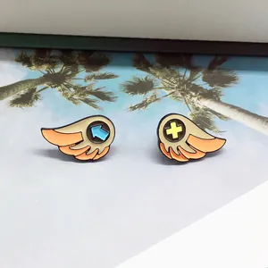 Set of two colorful cartoon wing enamel pins on a casual beach illustration background
