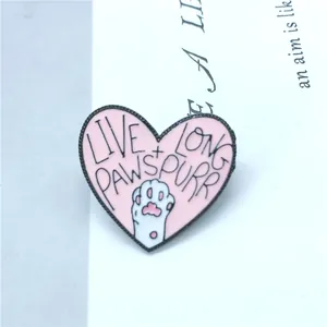 Gros plan détaillé d'une broche en émail rose en forme de cœur avec patte de chat