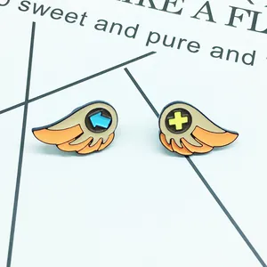 Detail view of cute cartoon wing enamel pins in orange and beige for couple jackets