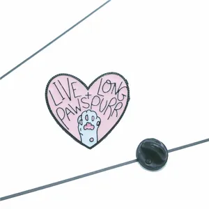 Détail du pin's émaillé cœur rose avec patte de chat blanche et texte Live Long Pawspurr