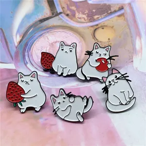 Lot de cinq épingles en émail chat blanc mignon avec détails fraise et pomme rouges