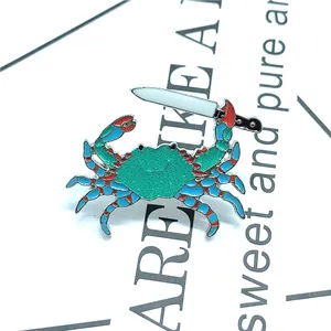 Makroaufnahme einer blauen Emaille-Krabbe Brosche mit Messer auf Displaykarte