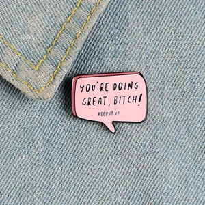 Spilla in smalto rosa a forma di fumetto con citazione su sfondo in denim blu