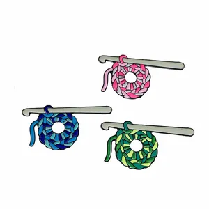 Three creative enamel pins featuring crochet yarn balls and silver hooks in various colors
