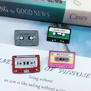 Detailed view of four retro cassette enamel pins with vintage 90s musical designs