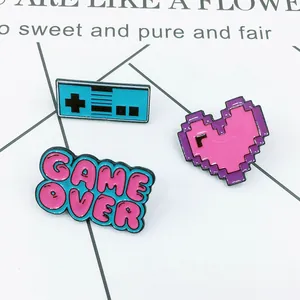 Enamel pin set featuring a blue retro game controller, pink pixel heart, and Game Over text