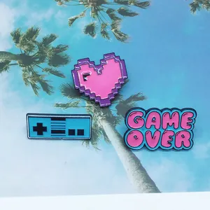 Retro pixel Game Over controller and heart enamel pins on tropical forest card
