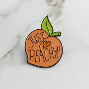 Broche en émail pêche mignonne avec texte Just Peachy sur fond de marbre blanc