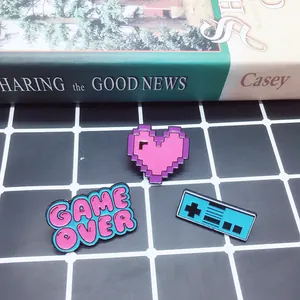 Close-up of retro game controller, Game Over sign and pixel heart enamel pin set
