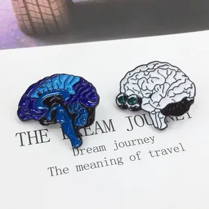 Dettaglio di spille in smalto a forma di cervello con design blu THINK e motivo bianco e nero