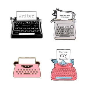 Set of four vintage typewriter enamel brooches in black, grey, pink, and red alloy